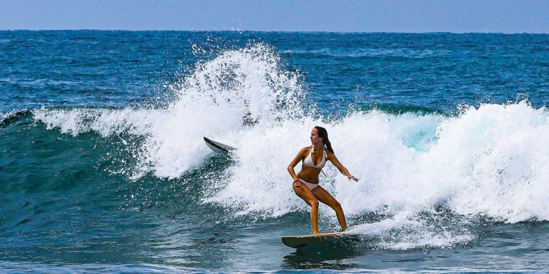mujer surfeando en la playa - que hacer en montañita ecuador
